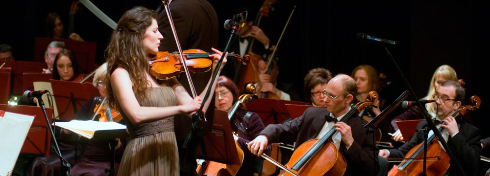 Musicians performing with violin and cello in an orchestra.